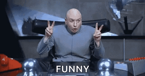 Bald Man Giving Peace Sign at Desk Saying Funny