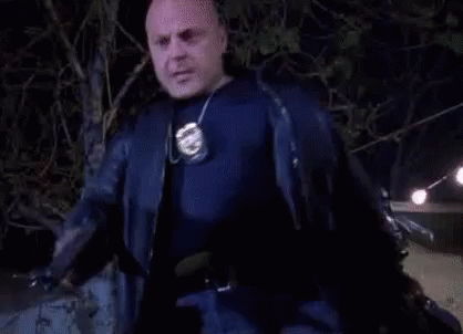 Bald Man in Black Jacket Holding Police Badge