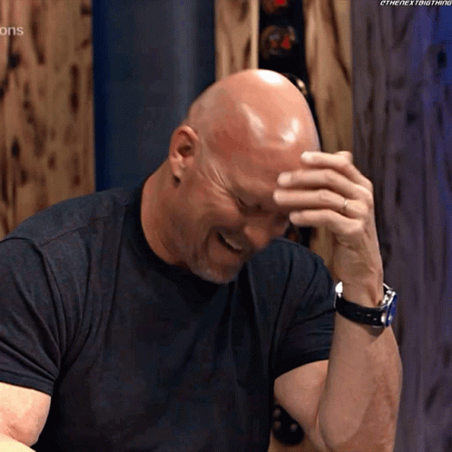 Bald Man in Black Shirt Covering Face With Hand
