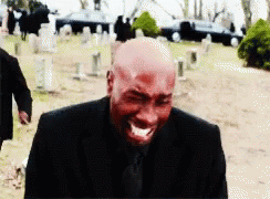 Bald Man in Black Suit Crying in Cemetery