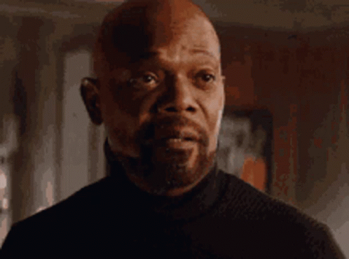 Bald Man in Black Turtleneck Looking at Camera