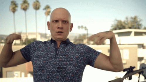 Bald Man in Blue Shirt Flexing Arms