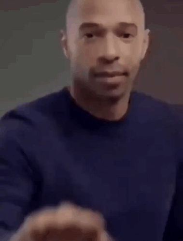 Bald Man In Blue Shirt Making Fist GIF