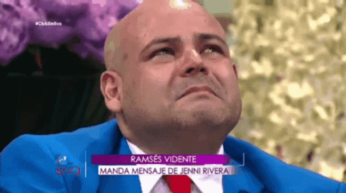 Bald Man in Blue Suit and Red Tie on TV Show