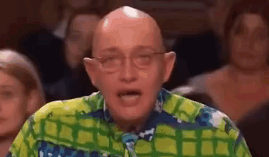 Bald Man in Glasses and Colorful Shirt Facing Crowd