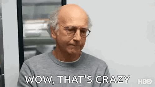 Bald Man In Glasses And Gray Sweater Saying Wow At Window GIF