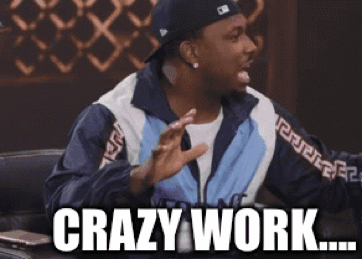 Bald Man In Glasses And Gray Sweater Saying Wow By Window GIF