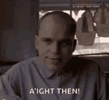 Bald Man In Gray Shirt Smiling By Window GIF