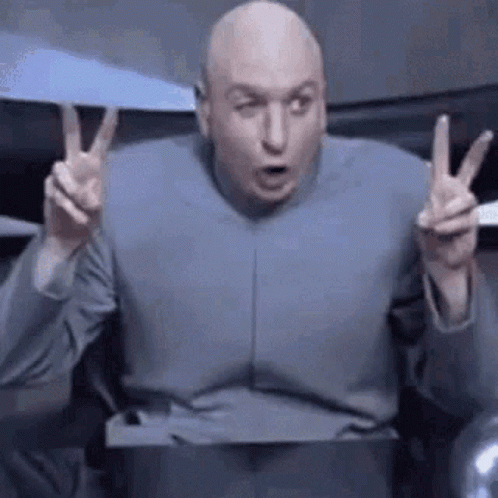 Bald Man in Gray Suit Giving Peace Sign
