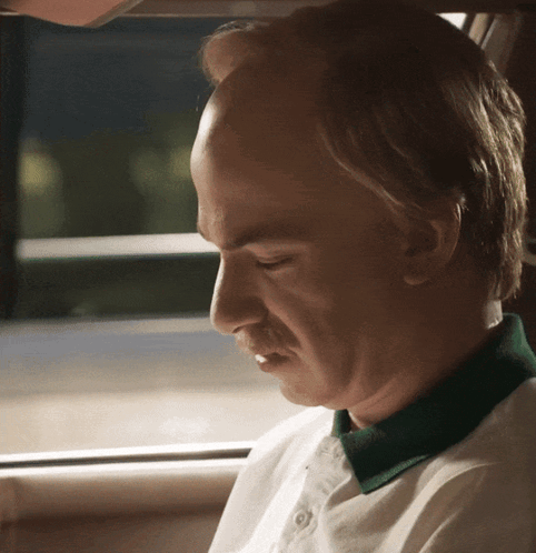 Bald Man In Green Collar Eyes Closed In Car