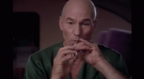 Bald Man in Green Shirt Smoking Cigarette