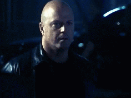 Bald Man in Leather Jacket Looking at Camera