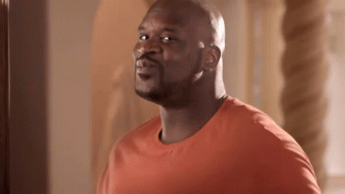 Bald Man in Orange Shirt Looking at Camera