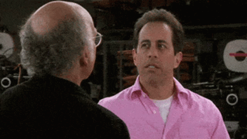 Bald Man in Pink Shirt Talking to Bald Man