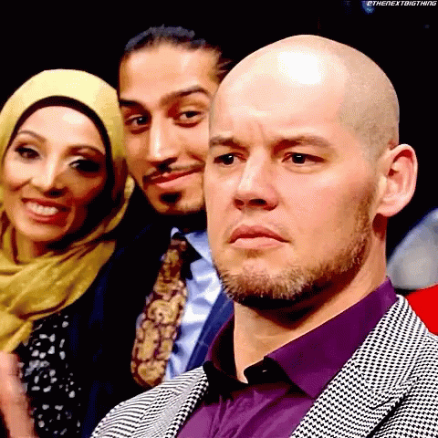 Bald Man In Purple Shirt In Front Of Group GIF