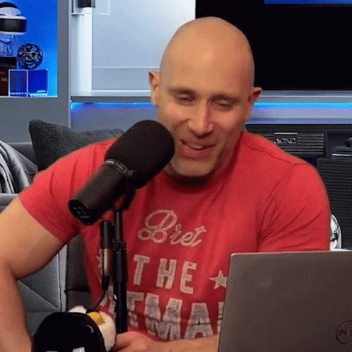 Bald Man in Red Shirt Bret at Microphone