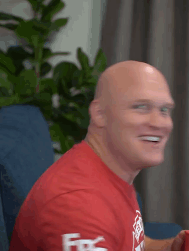Bald Man in Red Shirt Smiling Fire