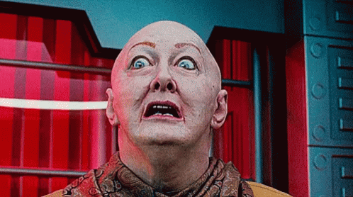 Bald Man in Scarf Looking Up at Camera