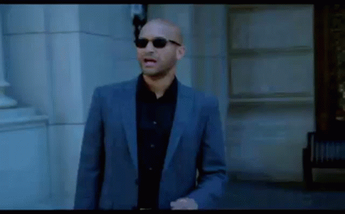 Bald Man in Suit and Sunglasses Walking