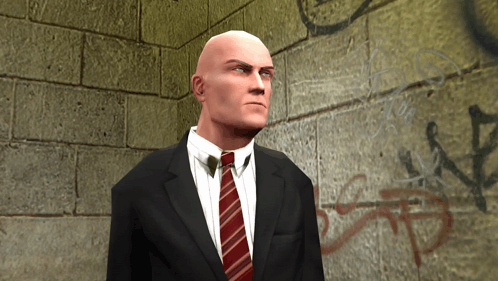 Bald Man in Suit and Tie in Front of Brick Wall