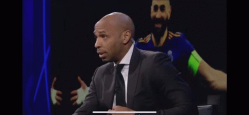 Bald Man in Suit and Tie in Front of Soccer Player