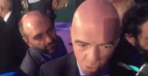 Bald Man in Suit and Tie Interviewed