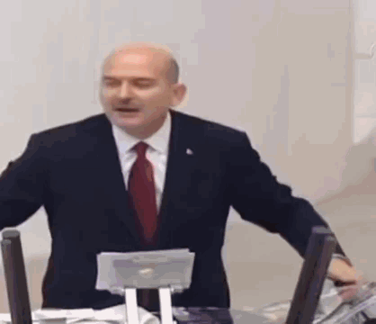Bald Man in Suit Standing by Computer