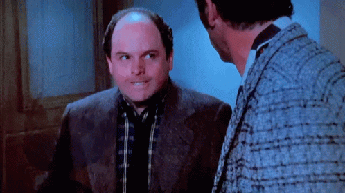 Bald Man in Suit Talking to Another Man