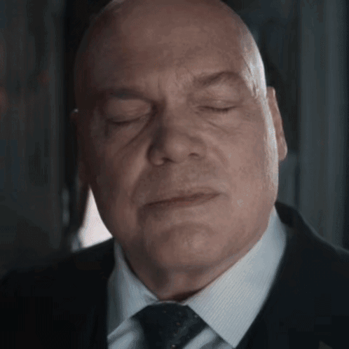 Bald Man in Suit with Eyes Closed
