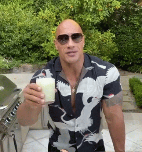 Bald Man in Sunglasses and Bird Shirt Holding Milk