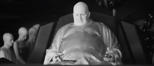 Bald Man in White Robe Sitting Black and White
