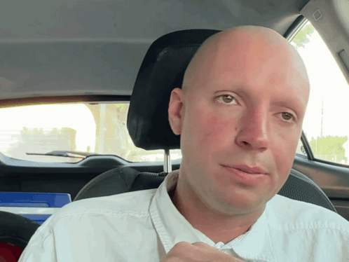 Bald Man in White Shirt Driving
