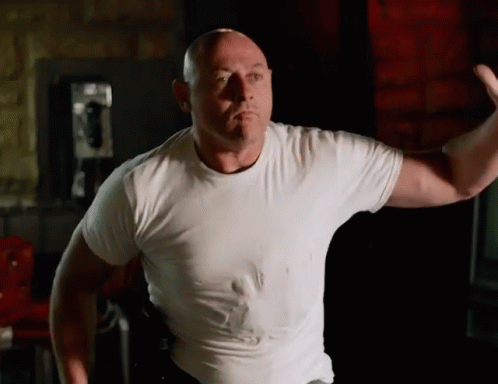 Bald Man In White T-Shirt Flexing Muscles GIF