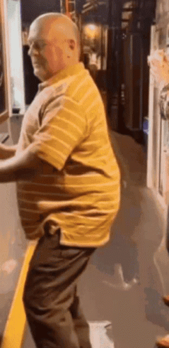 Bald Man in Yellow Striped Shirt and Black Pants