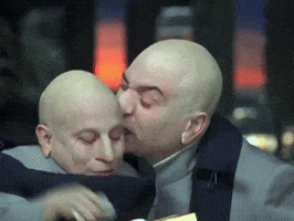 Bald Man Kisses Another Bald Man on Forehead