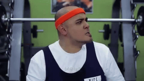 Bald Man Lifting Weights in Gym