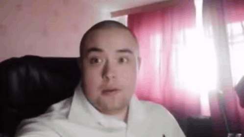 Bald Man Looking at Camera by Window
