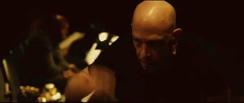Bald Man Looking in Dark Room