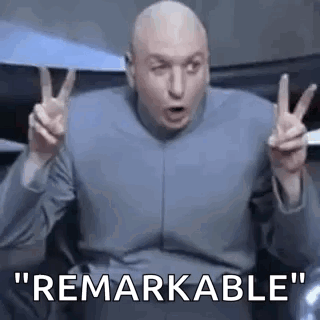 Bald Man Making Peace Sign While Sitting in Chair