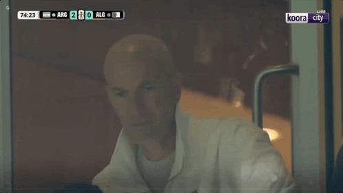 Bald Man Sitting in Front of TV Saying Live
