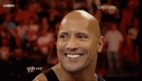 Bald Man Smiling at Wrestling Match