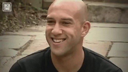 Bald Man Smiling in Black Shirt