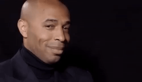 Bald Man Smiling in Suit and Turtleneck