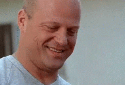 Bald Man Smiling With Eyes Closed and Mouth Open