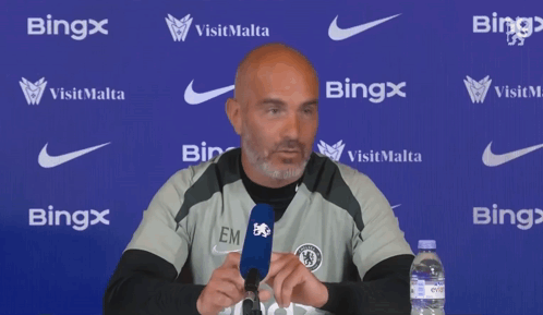 Bald Man Speaking Into Microphone In Front Of Bing Wall GIF