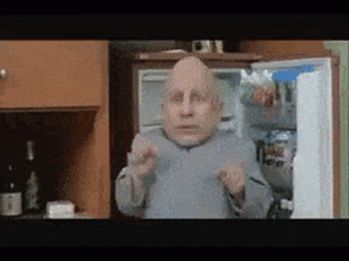 Bald Man Standing by Refrigerator