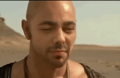 Bald Man Standing in Desert with Eyes Closed and Mouth Open