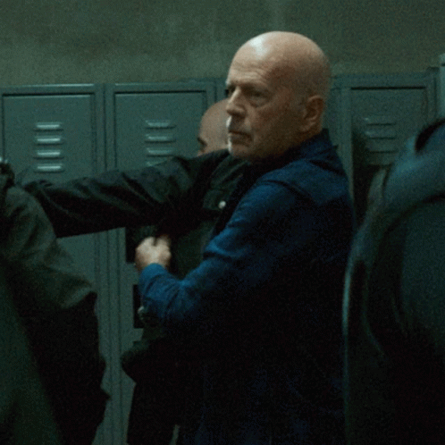 Bald Man Standing In Front Of Lockers GIF