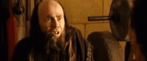 Bald Man With Beard and Long Hair Talking to Another Man