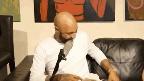 Bald Man with Beard Talking into Microphone